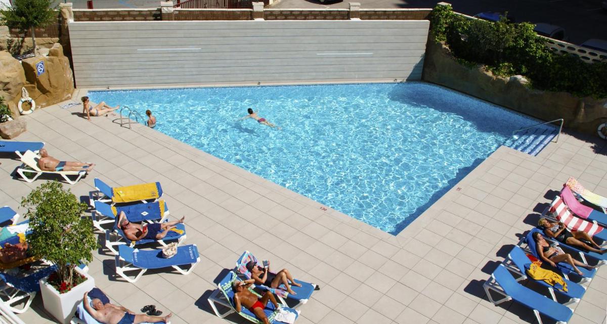 un grupo de personas sentadas en sillas en una piscina en Hotel RH Victoria & Spa 4 Sup, en Benidorm