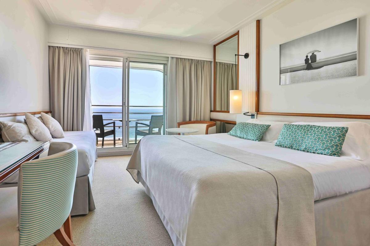 une chambre d'hôtel avec deux lits et un balcon dans l'établissement Atlantic Hôtel & Spa, à Les Sables-dʼOlonne