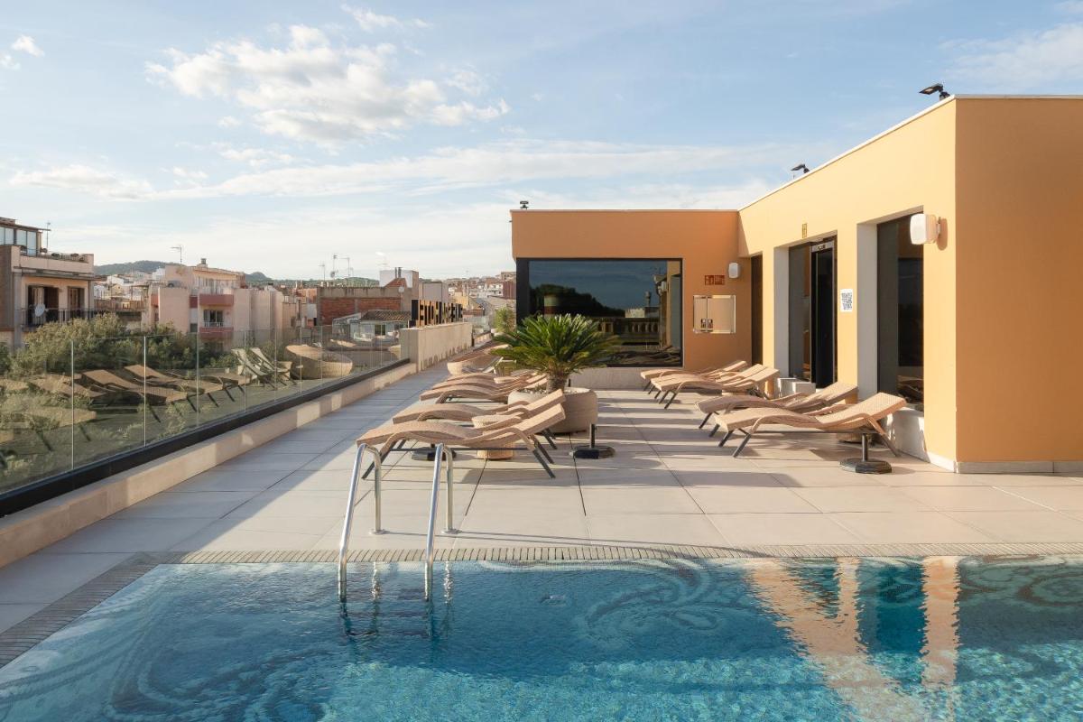 Un balcón con sillas y una piscina en un edificio. en Boutique Hotel Élke Spa Superior, en Sant Feliu de Guíxols