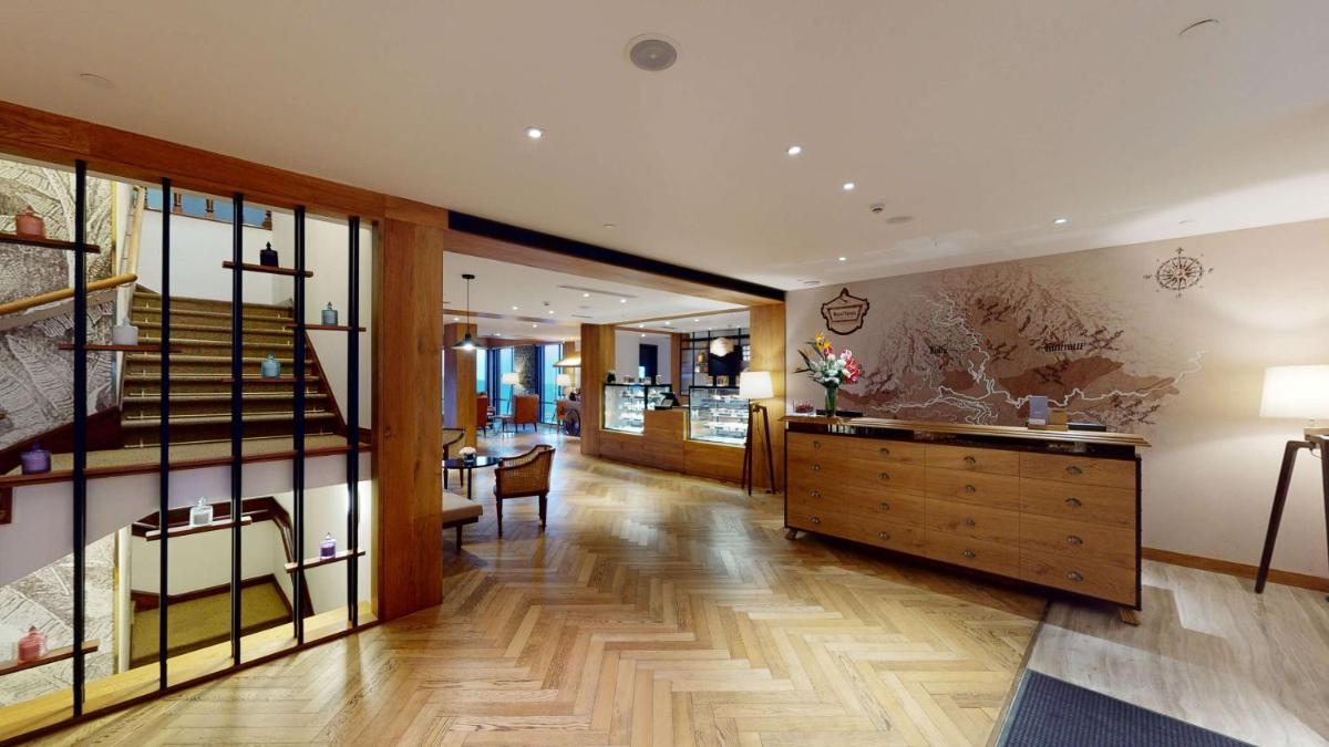 a living room with a staircase and a wooden dresser at Radisson Hotel Shimla in Shimla