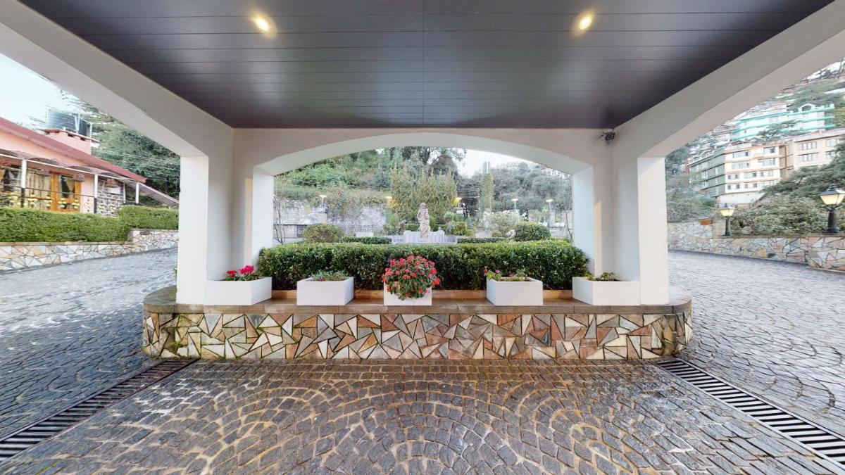a patio with a fountain and potted plants at Radisson Hotel Shimla in Shimla