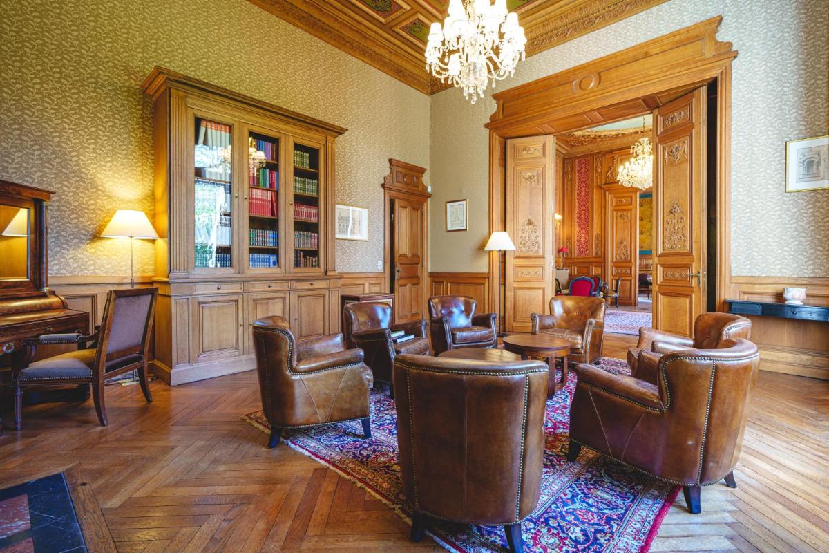 une salle d'attente avec des chaises et des tables en cuir ainsi qu'un lustre dans l'établissement Château La Comtesse de Loire & Spa, à Saumur 28 autres photos
