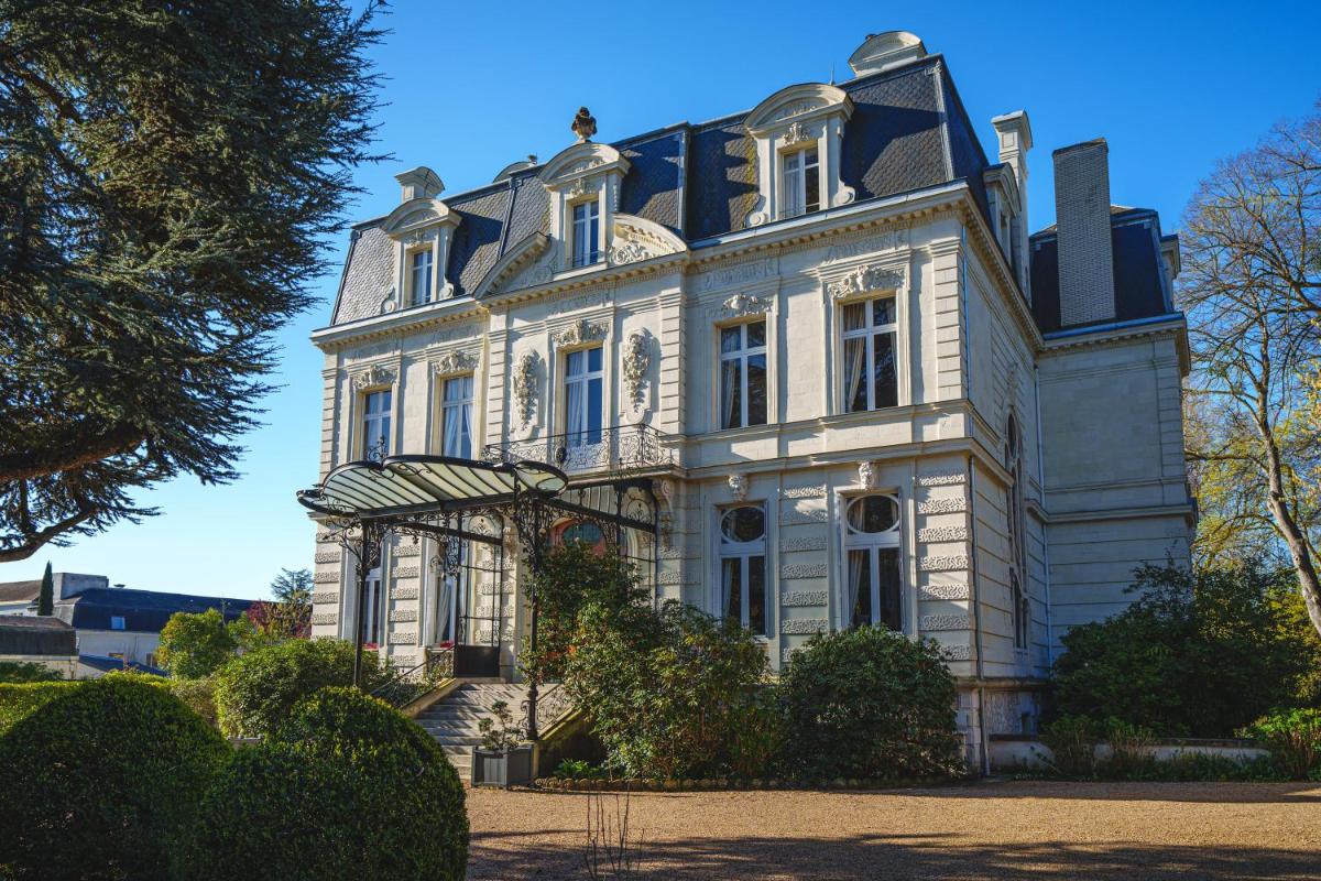 une grande maison blanche avec un gambrel dans l'établissement Château La Comtesse de Loire & Spa, à Saumur