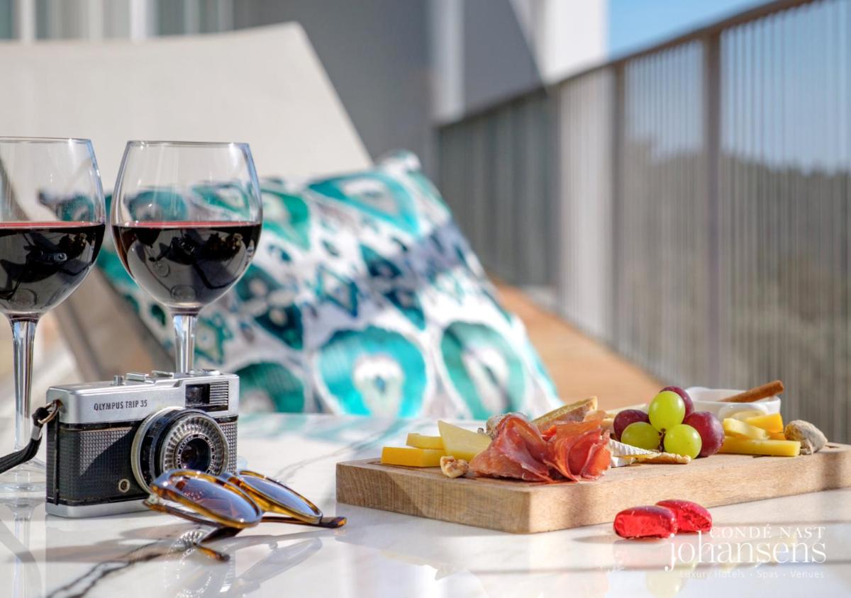 uma mesa com duas taças de vinho e uma câmera em Pure Monchique Hotel - Villa Termal Spa Resort - by Unlock Hotels em Monchique