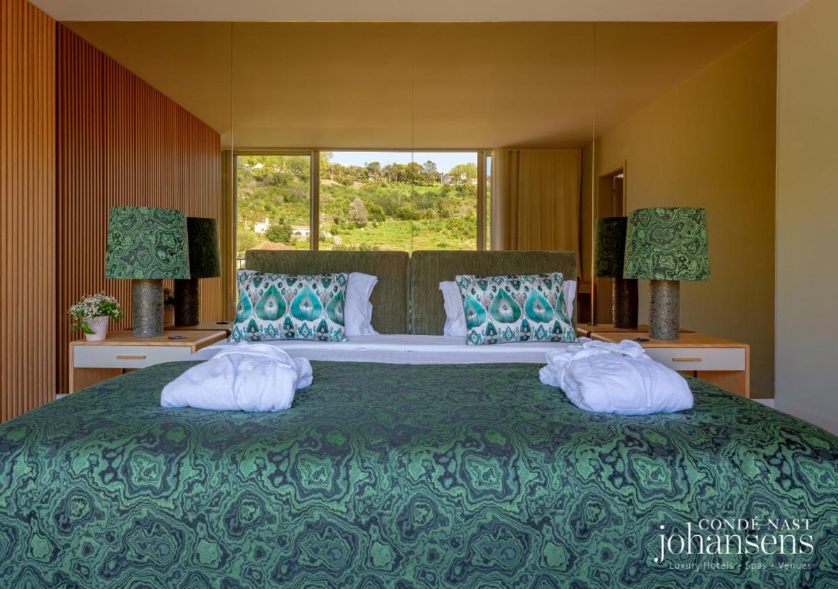 um quarto com uma cama grande com almofadas e uma janela em Pure Monchique Hotel - Villa Termal Spa Resort - by Unlock Hotels em Monchique mais 38 fotografias