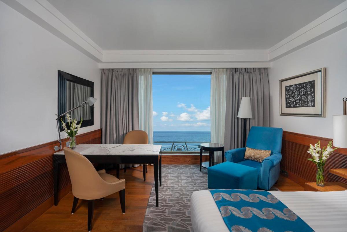 a hotel room with a bed and a dining room at InterContinental Marine Drive Mumbai by IHG in Mumbai