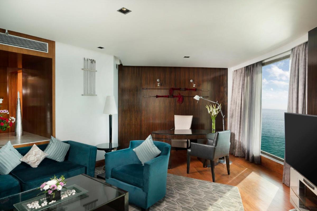a living room with a blue couch and a table at InterContinental Marine Drive Mumbai by IHG in Mumbai