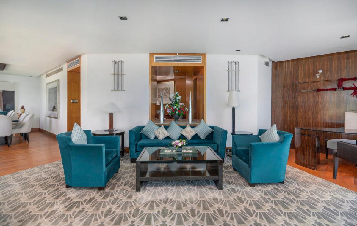 a living room with blue chairs and a coffee table at InterContinental Marine Drive Mumbai by IHG in Mumbai