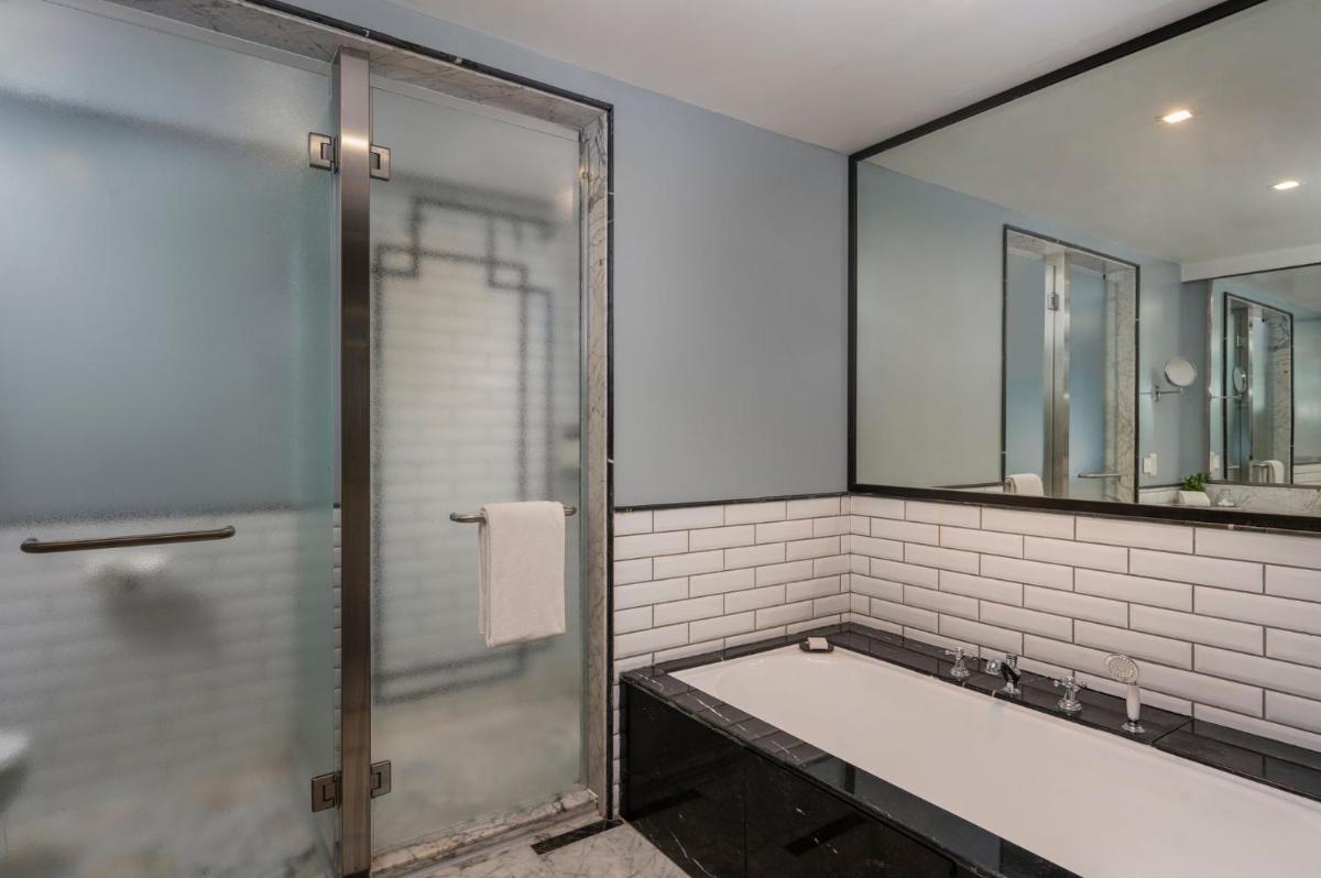 a bathroom with a tub and a shower with a mirror at InterContinental Marine Drive Mumbai by IHG in Mumbai