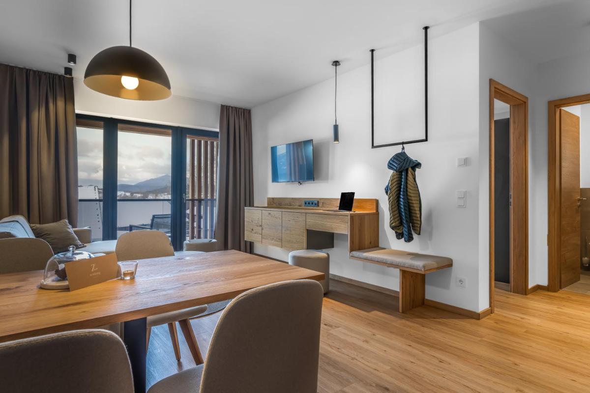 ein Esszimmer mit einem Holztisch und Stühlen in der Unterkunft zeitlang by Rösslwirt in Lam