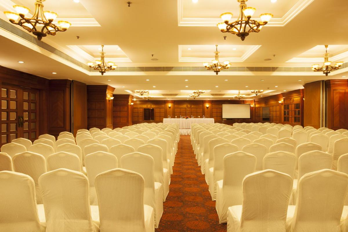 a banquet hall with white chairs and a stage at The Accord Metropolitan in Chennai