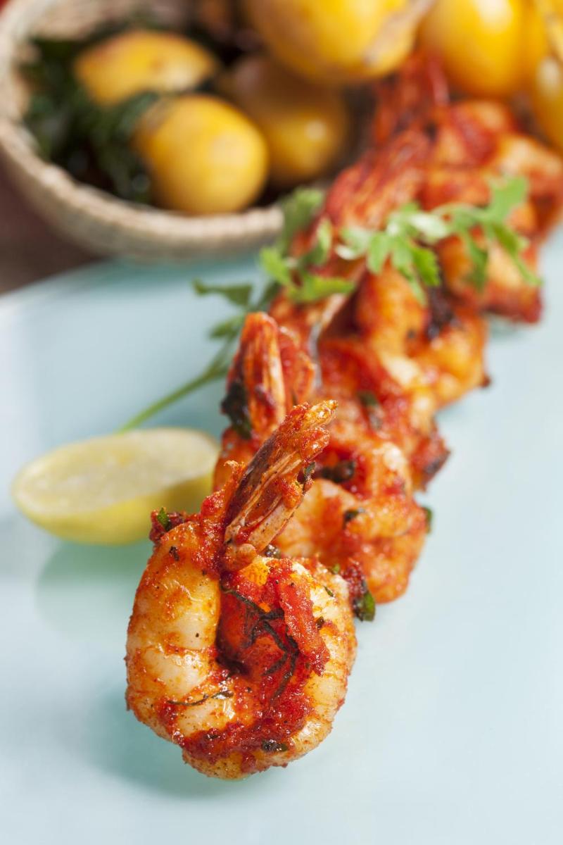 a plate of food with shrimp and a bowl of lemons at The Accord Metropolitan in Chennai