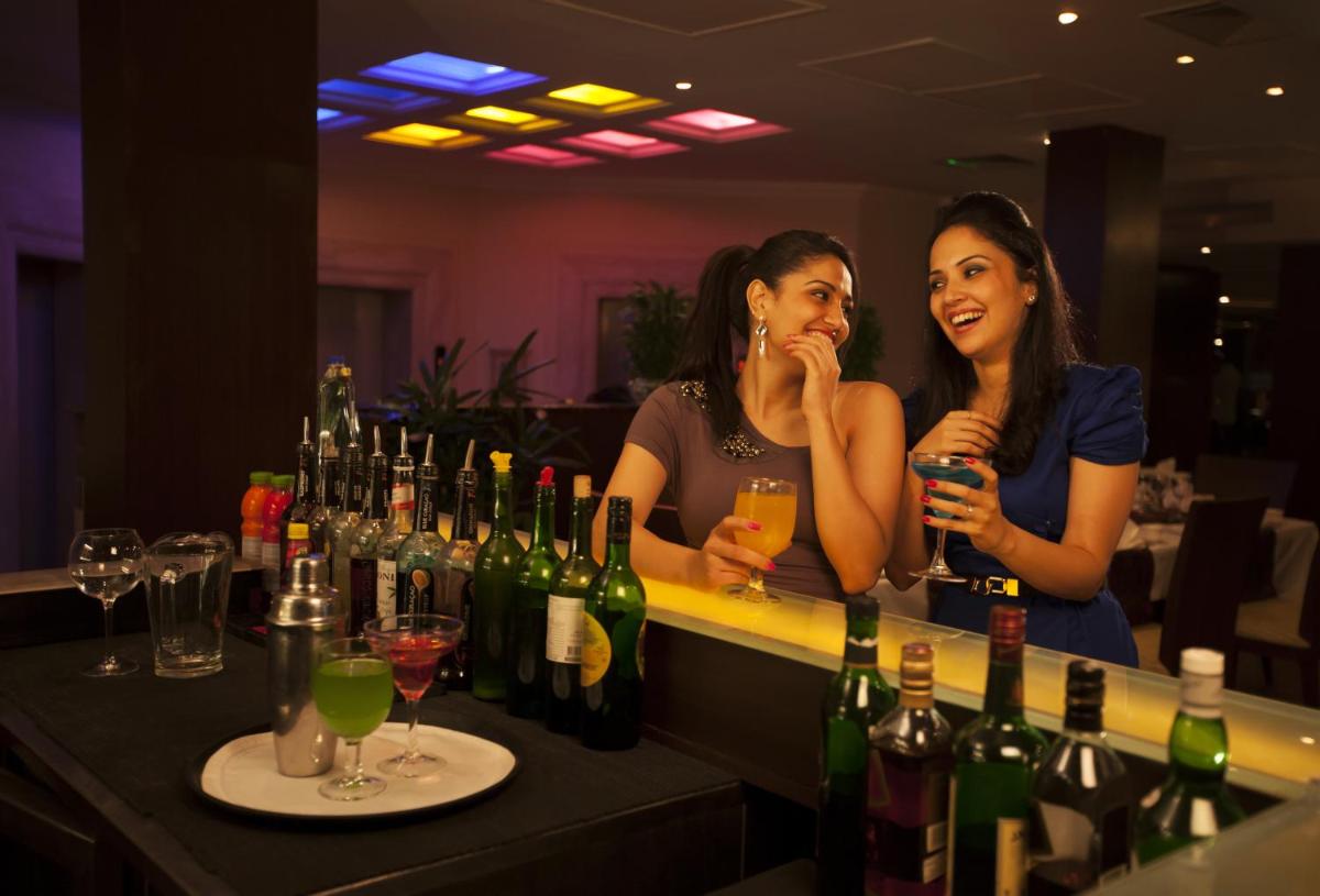 two women standing at a bar with wine bottles at The Accord Metropolitan in Chennai
