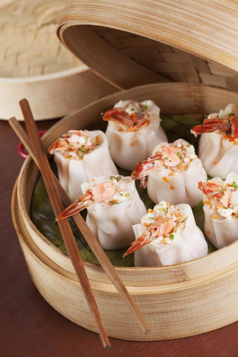 a wooden bowl of food with chopsticks in it at The Accord Metropolitan in Chennai