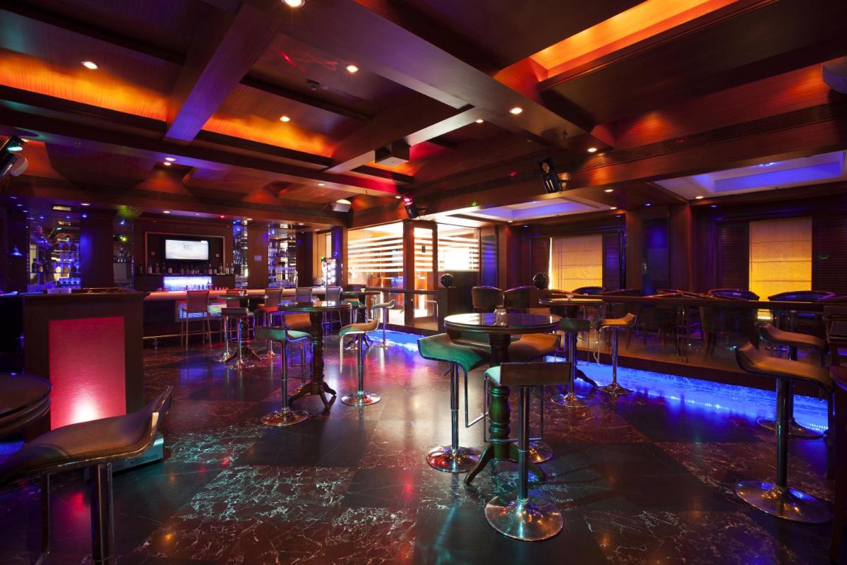 a bar with a lot of stools in a room at The Accord Metropolitan in Chennai