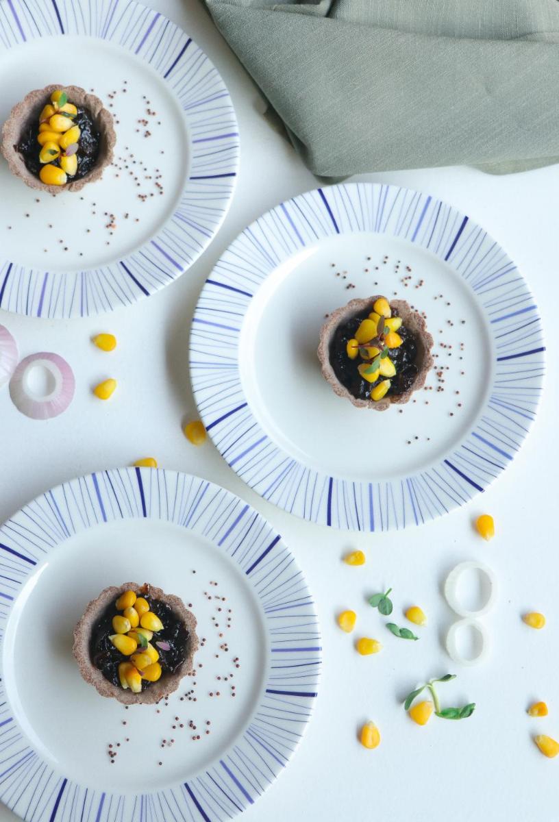 a table topped with white plates topped with chocolate cookies at Crowne Plaza Pune City Centre by IHG in Pune