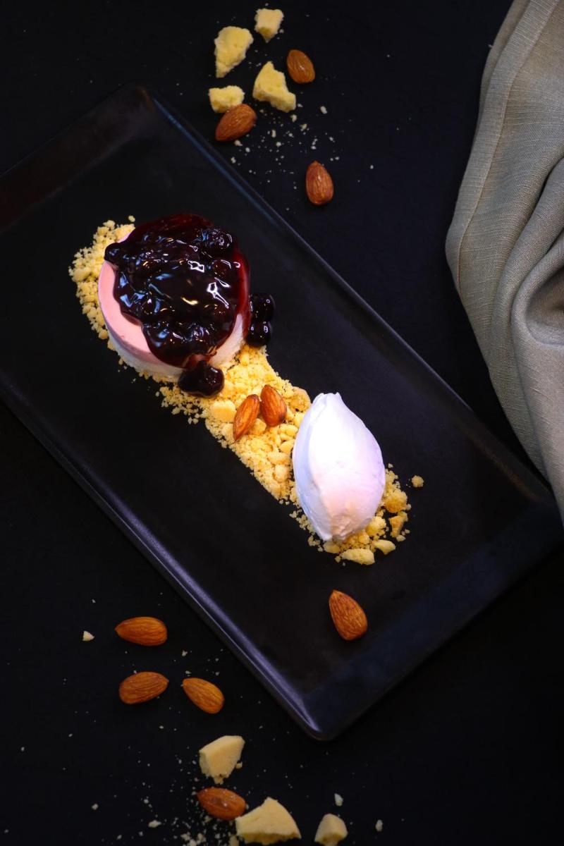 a dessert on a black plate with ice cream and nuts at Crowne Plaza Pune City Centre by IHG in Pune