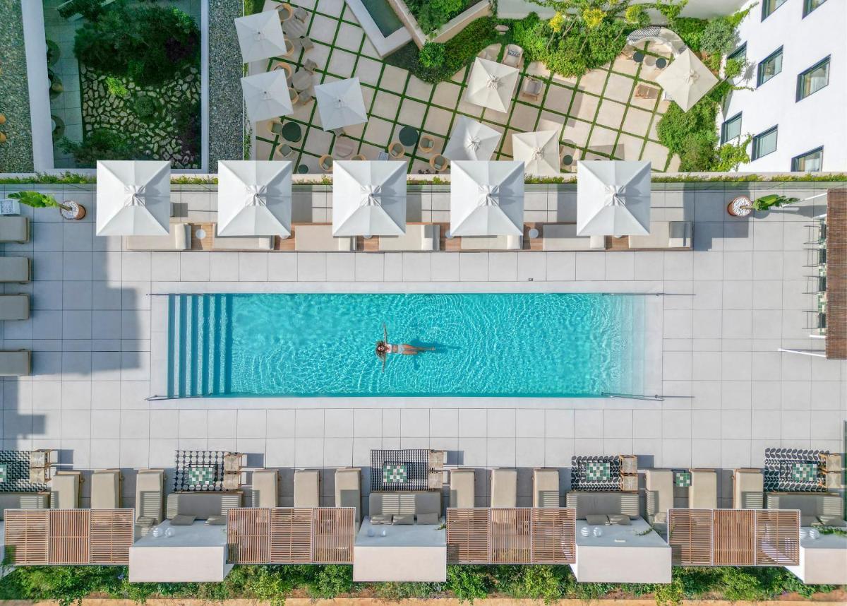 Una vista aérea de una piscina con sillas y una persona nadando. en HM Palma Blanc, en Palma de Mallorca