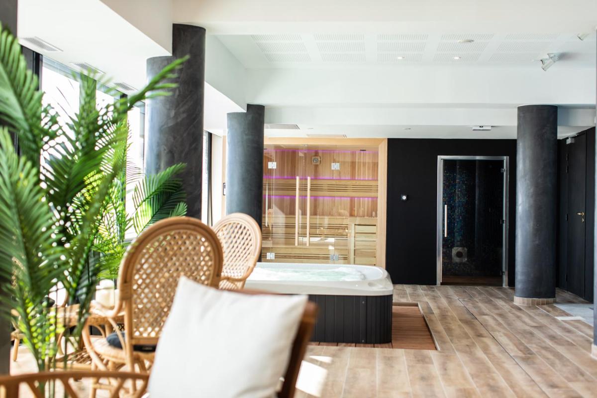 Coin salon dans l'établissement Le Barracuda & Spa, pieds dans l'eau, vue mer, espace bien-être offert