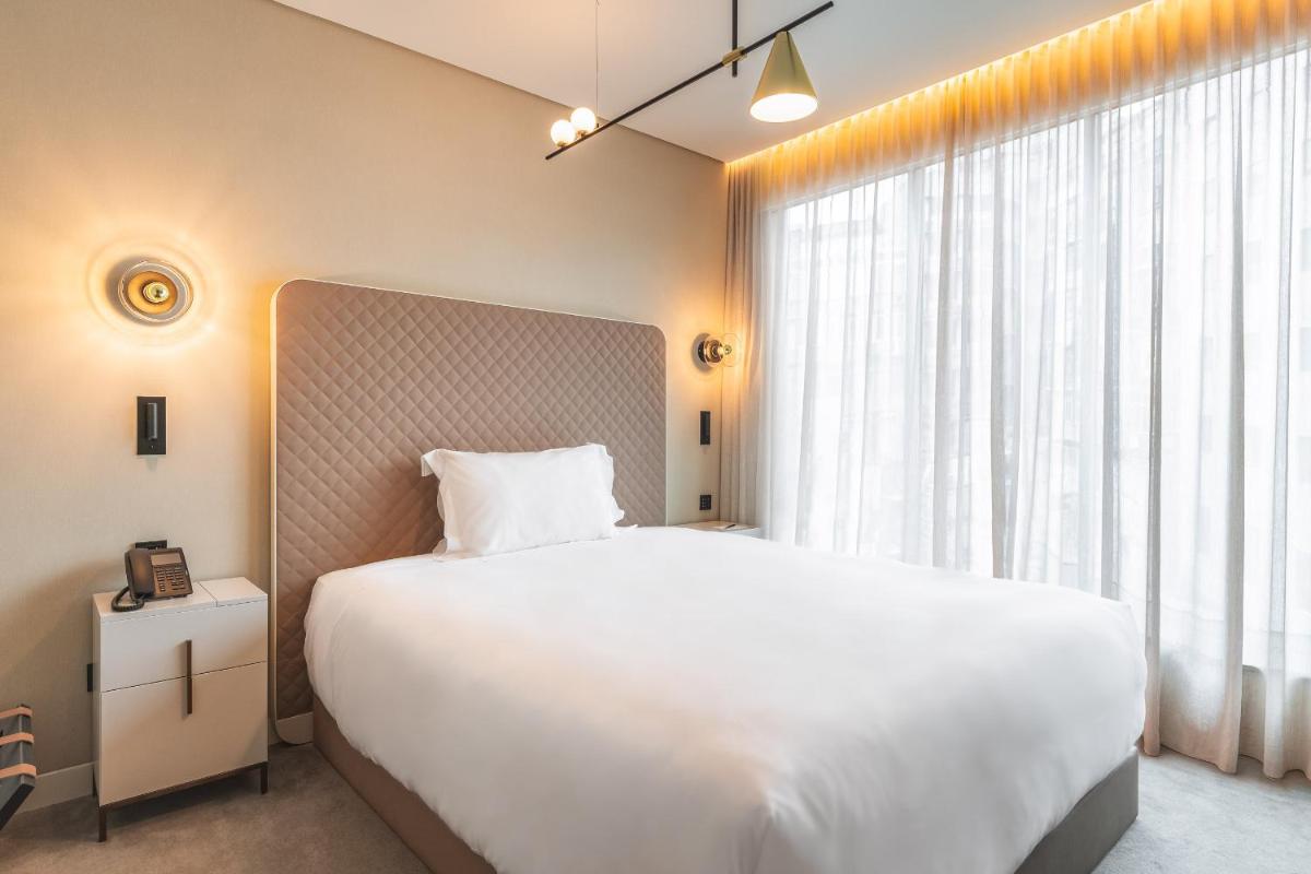 Uma cama ou camas num quarto em LUSTER Hotel