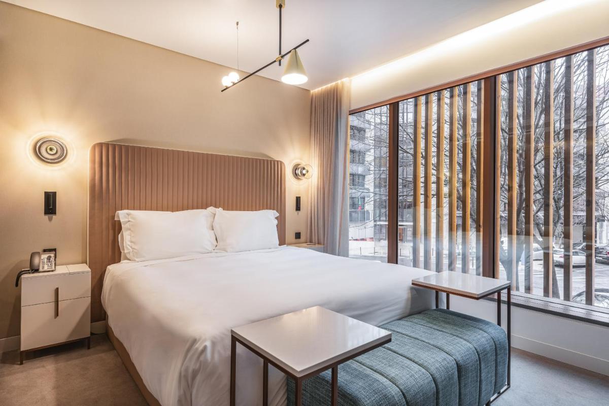 um quarto com uma cama e uma janela grande em LUSTER Hotel em Lisboa
