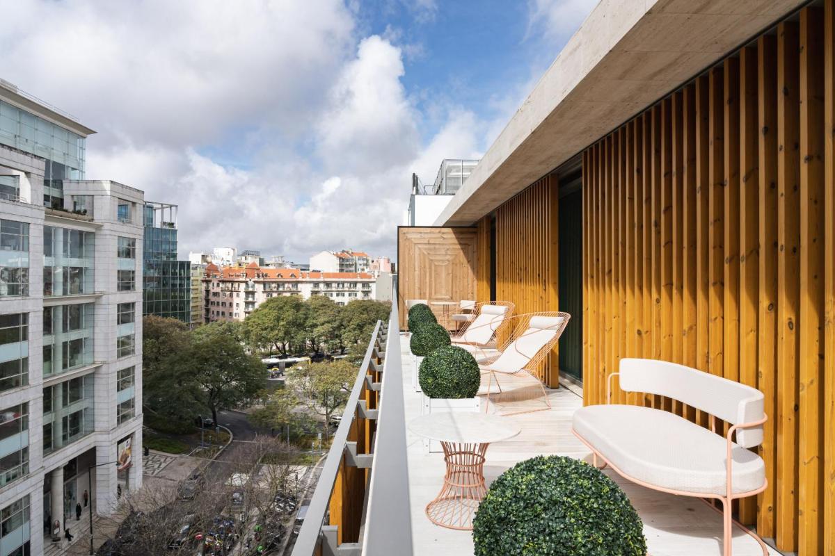 uma varanda com cadeiras e plantas num edifício em LUSTER Hotel em Lisboa