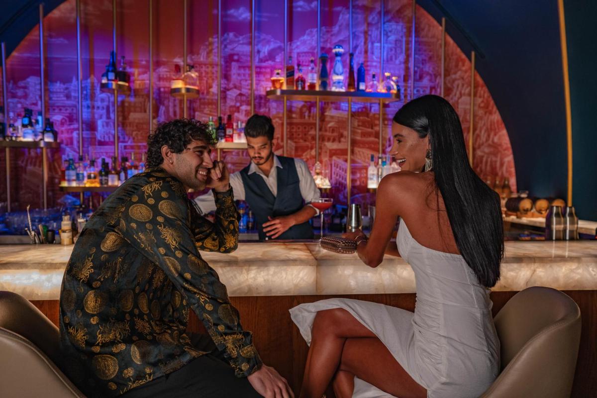 a man and a woman sitting at a bar at FIVE Palm Jumeirah Dubai in Dubai a man and a woman sitting at a bar at FIVE Palm Jumeirah Dubai in Dubai