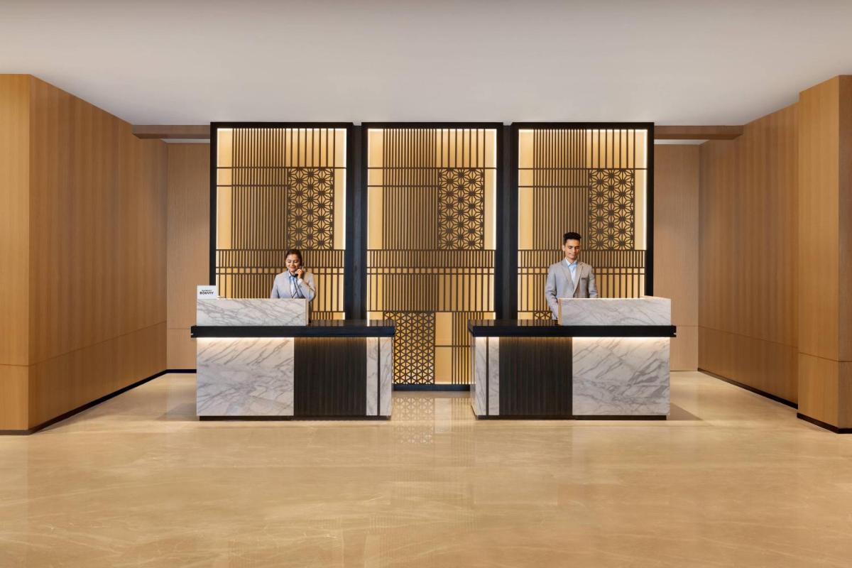 two men are sitting at desks in a lobby at Fairfield by Marriott Dehradun in Dehradun