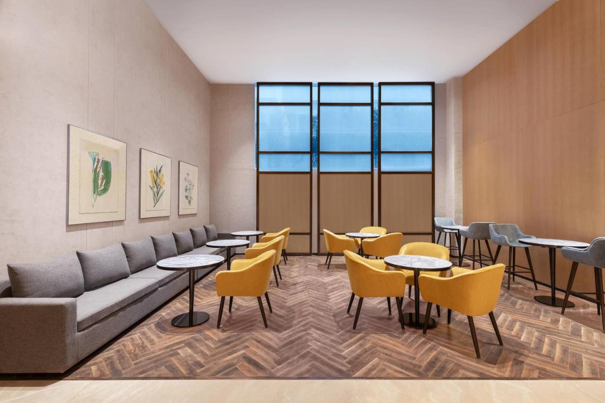 a waiting room with tables and yellow chairs at Fairfield by Marriott Dehradun in Dehradun
