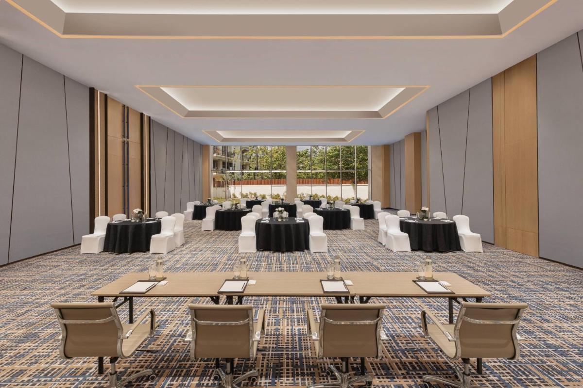 a conference room with tables and chairs and a large room with windows at Fairfield by Marriott Dehradun in Dehradun