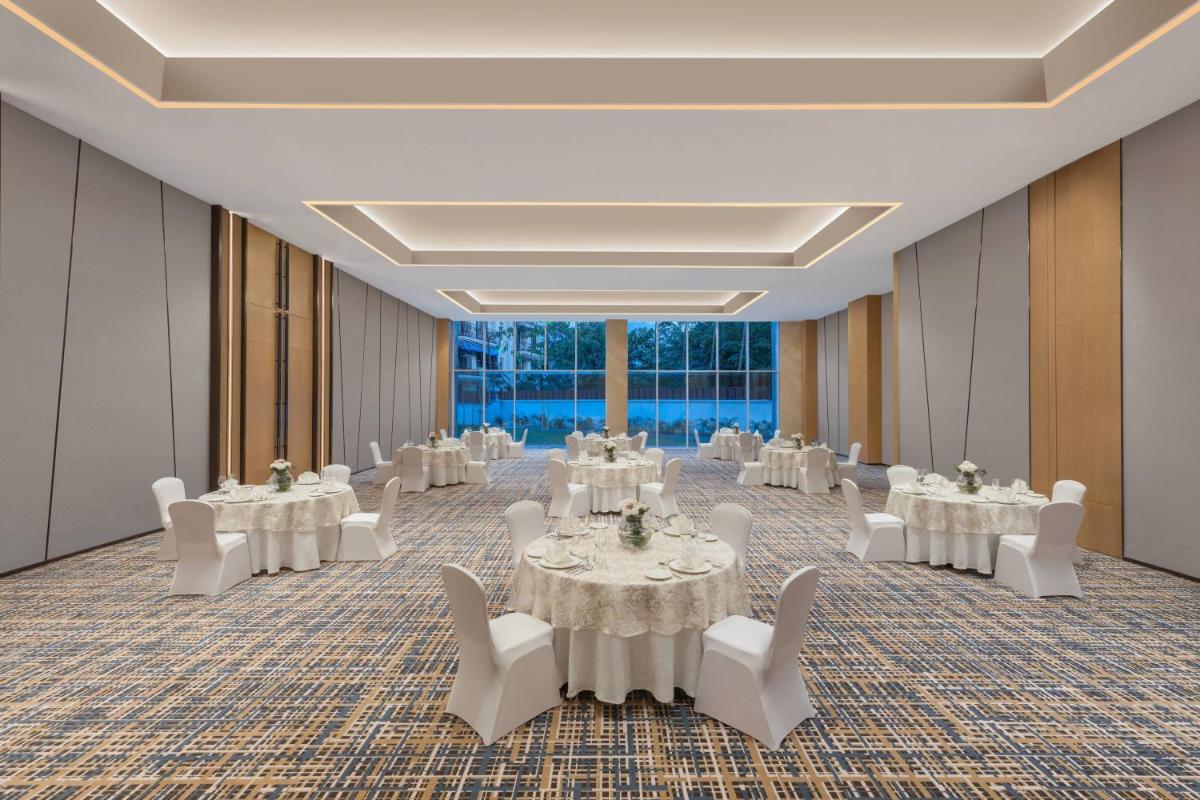 a banquet hall with tables and white chairs at Fairfield by Marriott Dehradun in Dehradun