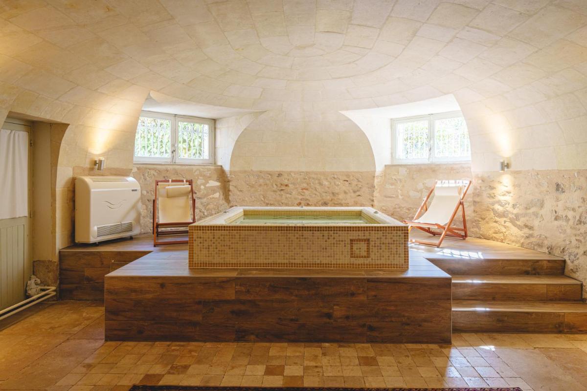 une chambre avec baignoire au milieu d'une pièce dans l'établissement Château La Comtesse de Loire & Spa, à Saumur