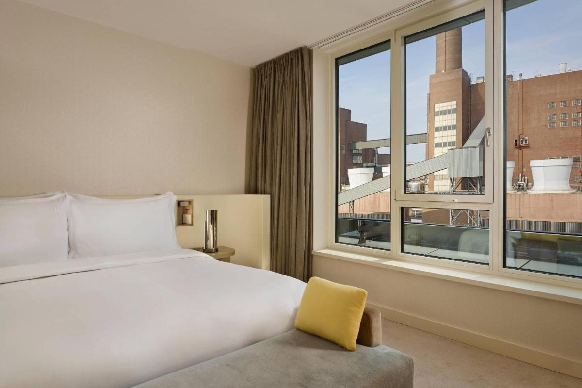 ein Schlafzimmer mit einem Bett und einem großen Fenster in der Unterkunft The Ritz-Carlton, Wolfsburg in Wolfsburg