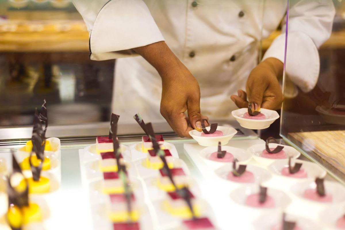 a chef preparing food on top of a counter at Crowne Plaza Ahmedabad City Centre by IHG in Ahmedabad