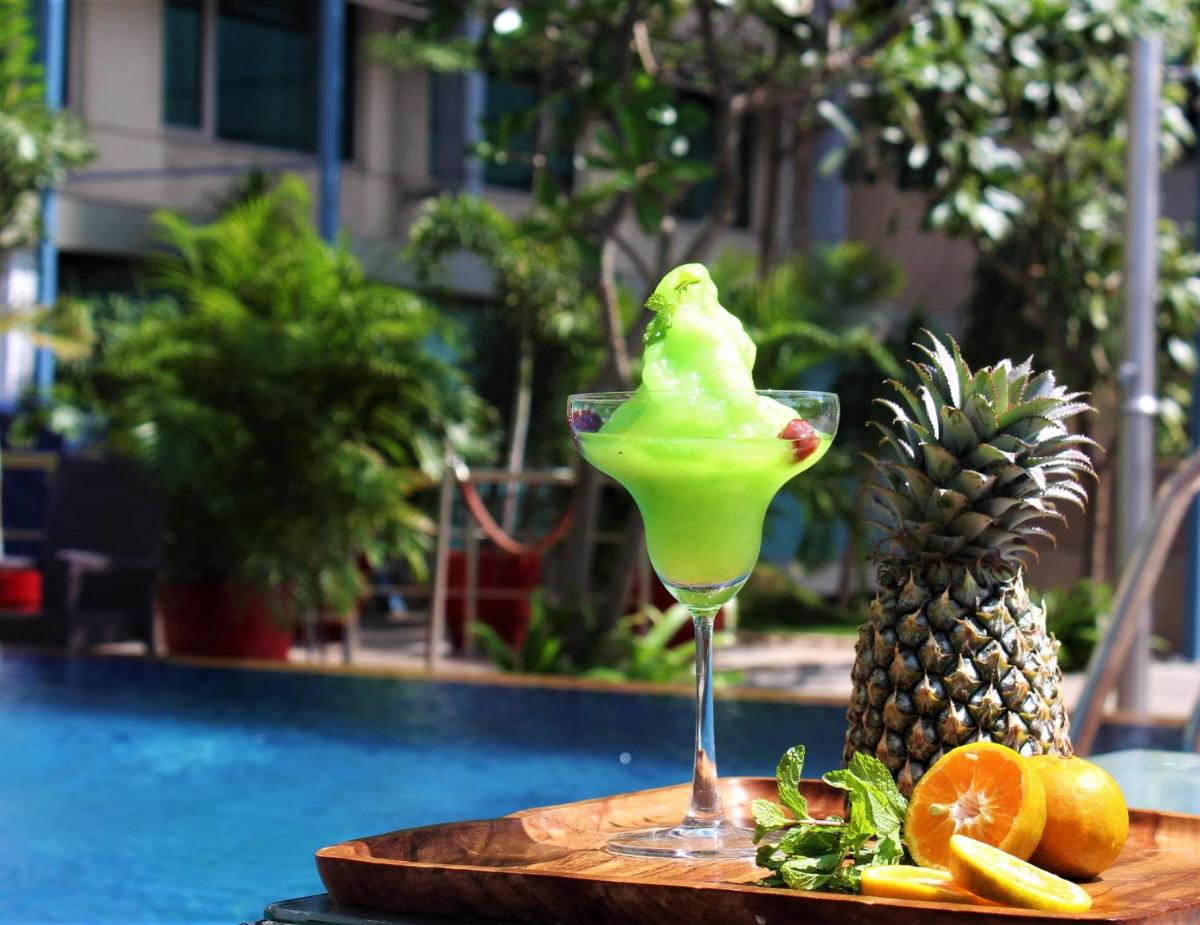 a drink in a martini glass next to a pineapple at Crowne Plaza Ahmedabad City Centre by IHG in Ahmedabad