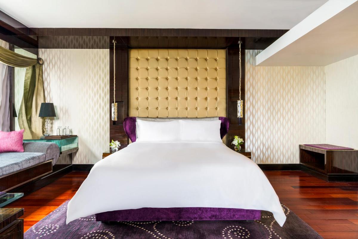 a bedroom with a large bed and a couch at Sofitel Mumbai BKC in Mumbai