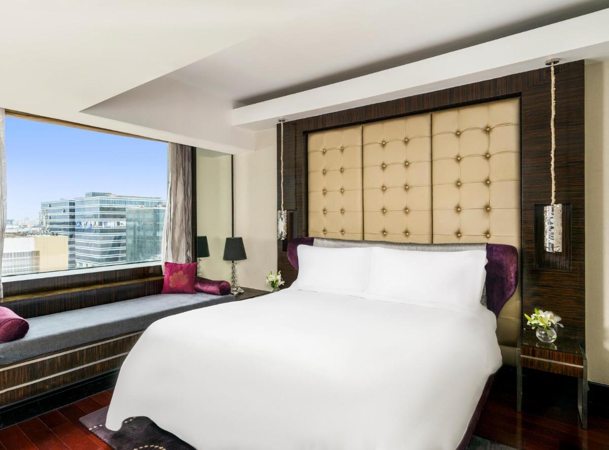 a bedroom with a large white bed and a window at Sofitel Mumbai BKC in Mumbai