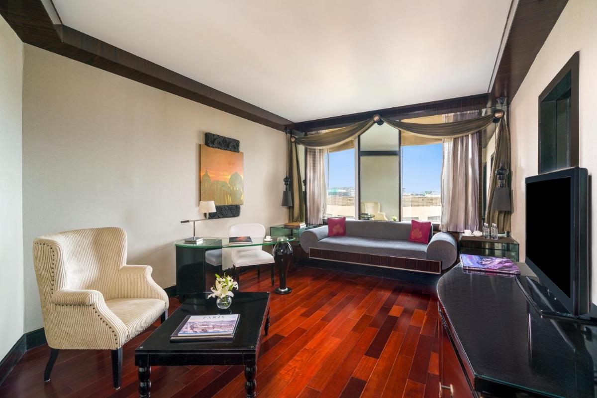 a living room with a couch and a tv at Sofitel Mumbai BKC in Mumbai