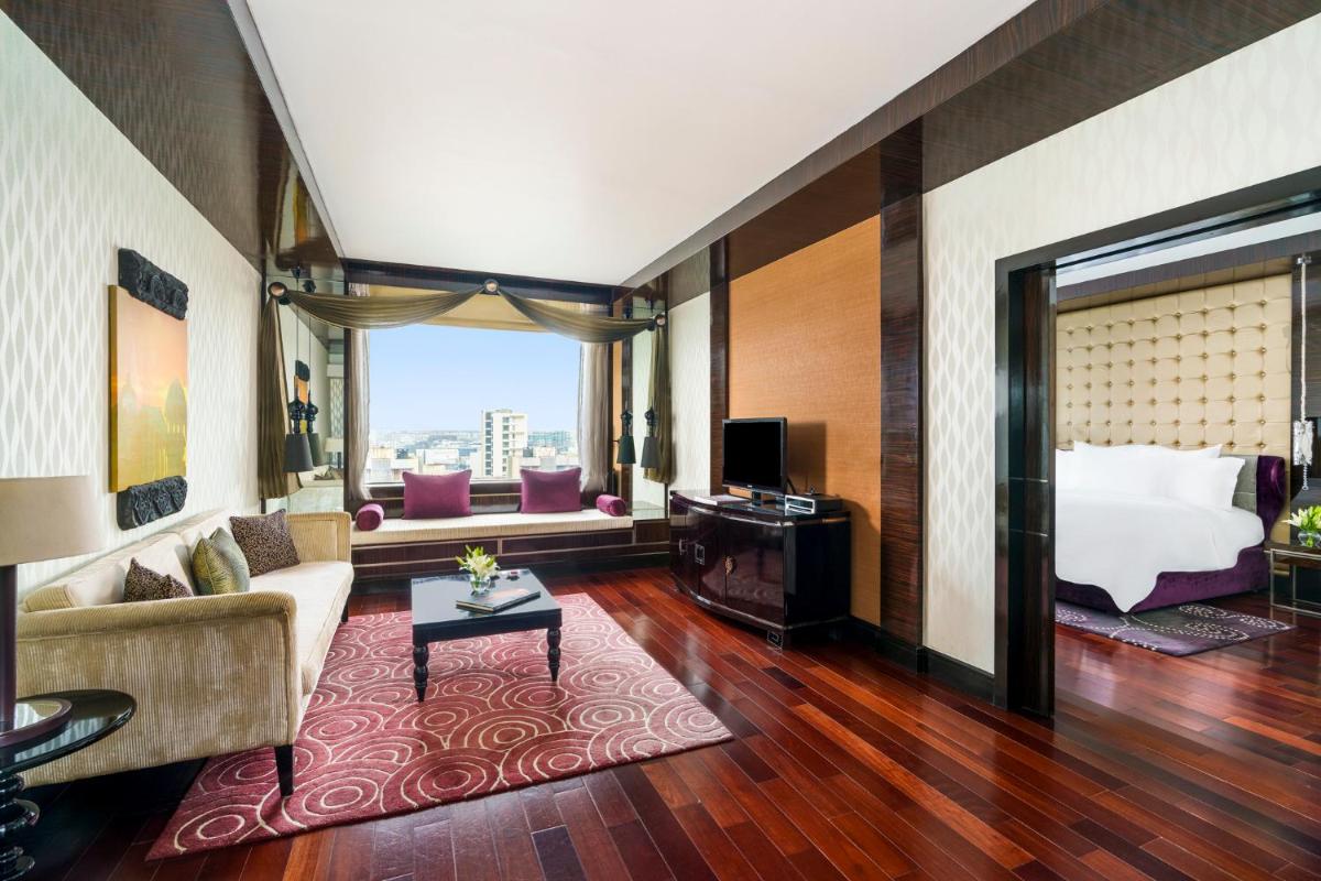 a hotel room with a bed and a couch at Sofitel Mumbai BKC in Mumbai