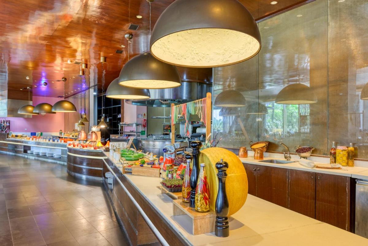 a large kitchen with a buffet line in a restaurant at Novotel Bengaluru Outer Ring Road in Bengaluru