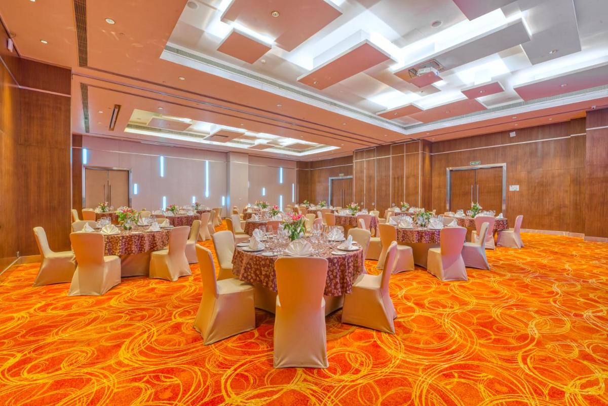 a banquet hall with tables and chairs in a room at Novotel Bengaluru Outer Ring Road in Bengaluru