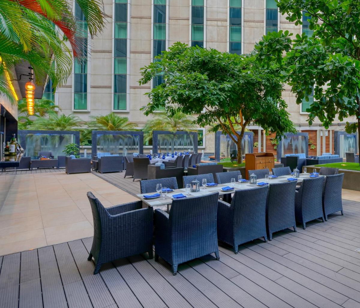 a restaurant with tables and chairs and a building at Novotel Bengaluru Outer Ring Road in Bengaluru