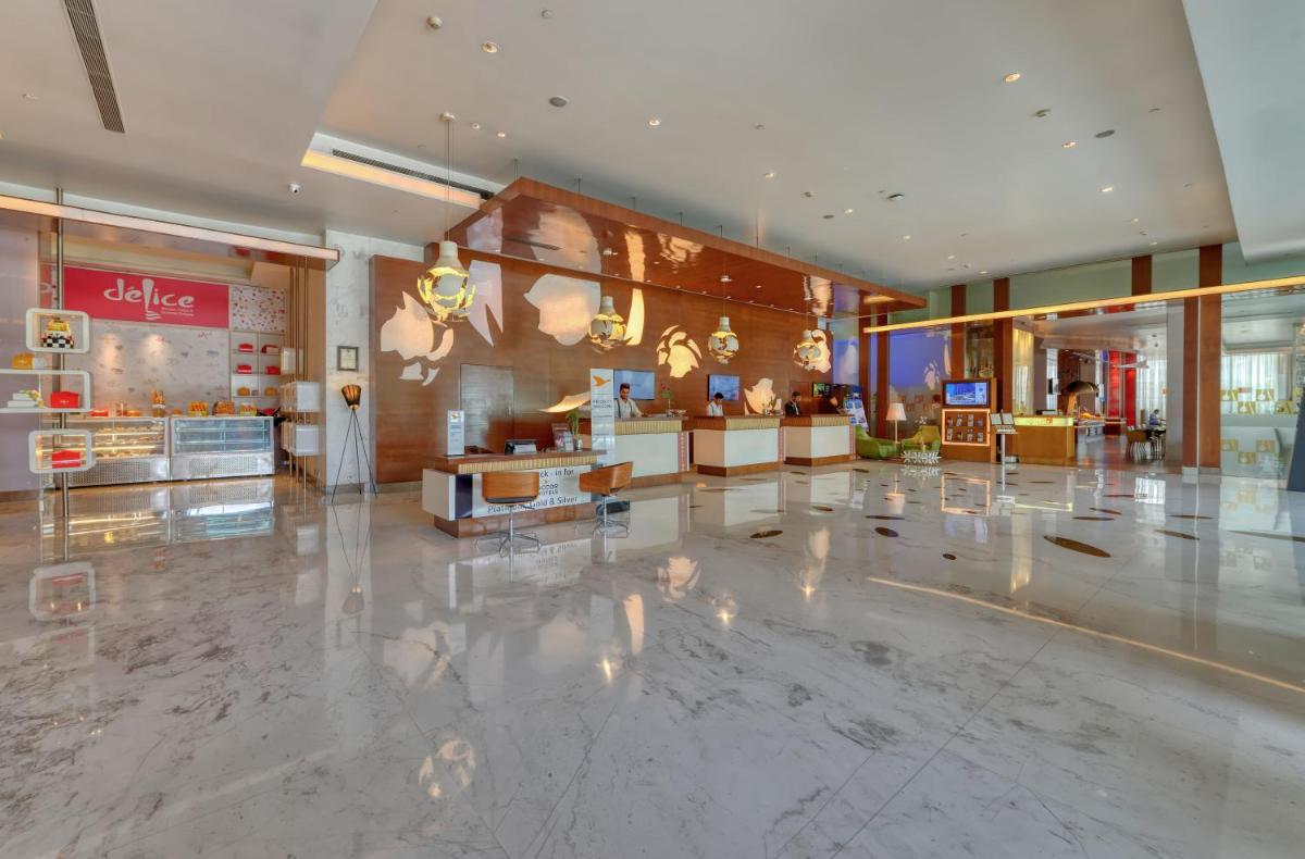 a lobby of a shopping mall with a store at Novotel Bengaluru Outer Ring Road in Bengaluru