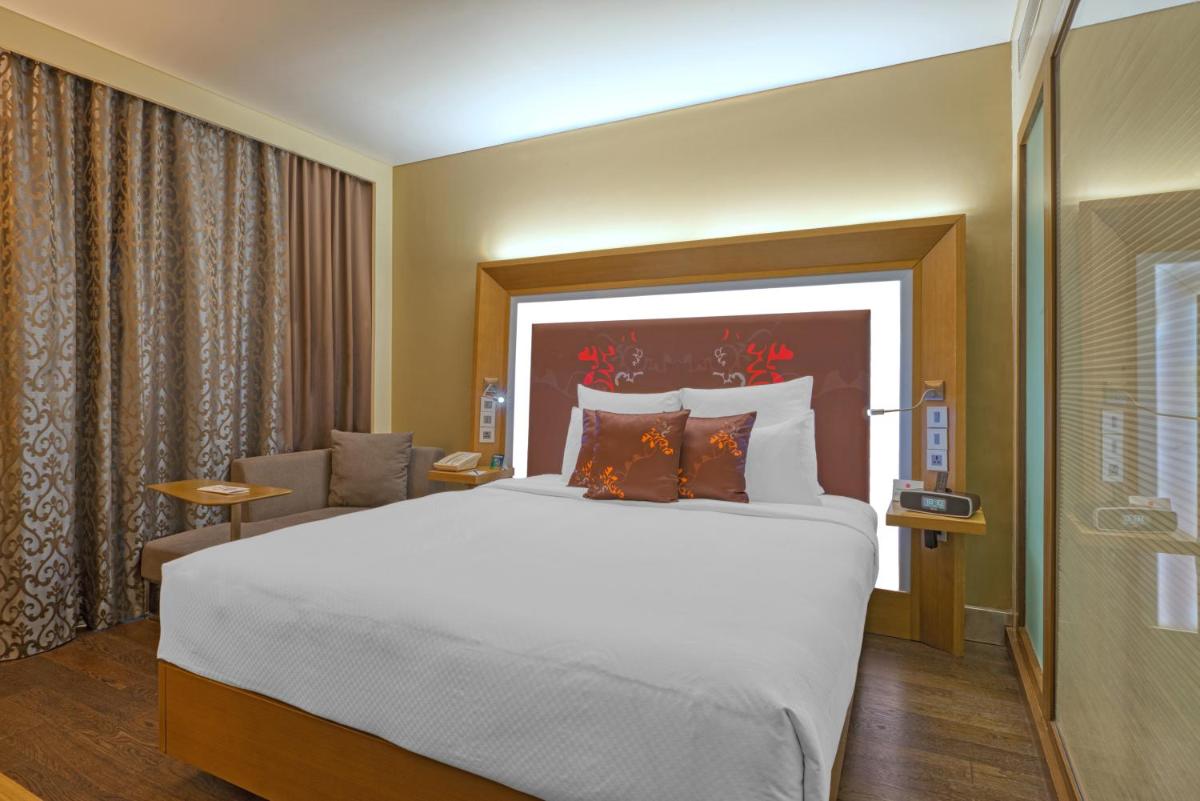 a bedroom with a large bed in a hotel room at Novotel Bengaluru Outer Ring Road in Bengaluru