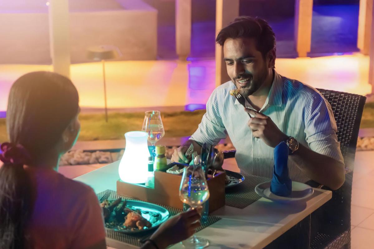 a man sitting at a table with a woman at Novotel Bengaluru Outer Ring Road in Bengaluru