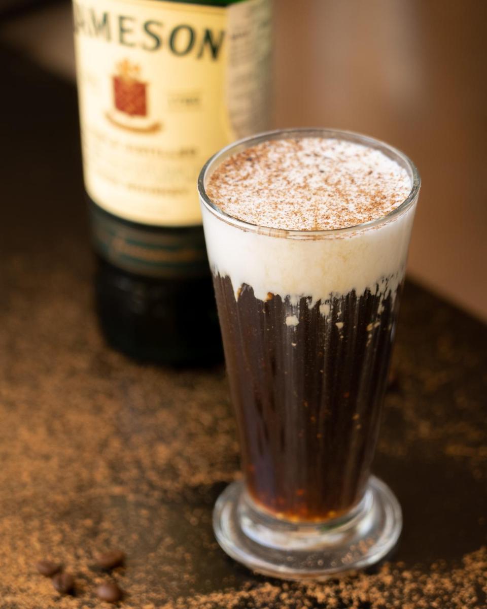 a drink in a glass next to a bottle of wine at Novotel Bengaluru Outer Ring Road in Bengaluru