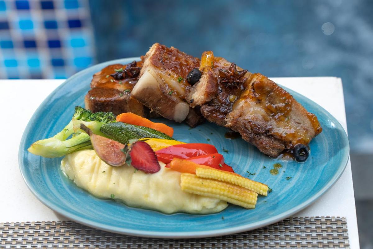 a blue plate of food with meat and vegetables at Novotel Bengaluru Outer Ring Road in Bengaluru