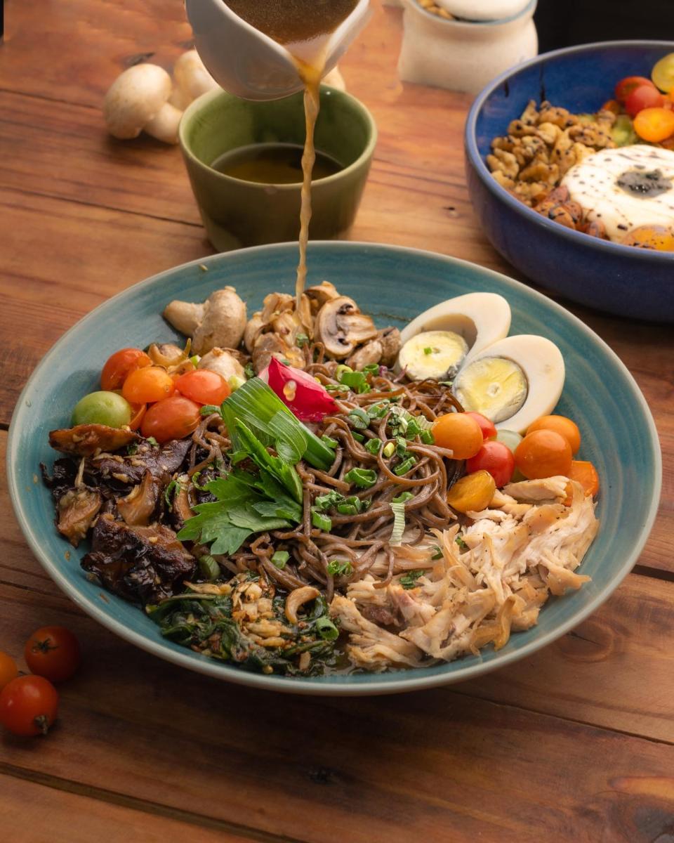 a blue bowl of food on a wooden table at Novotel Bengaluru Outer Ring Road in Bengaluru