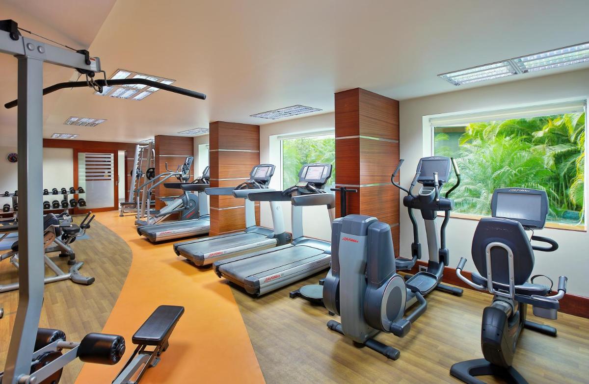 a gym with treadmills and elliptical machines at Novotel Bengaluru Outer Ring Road in Bengaluru