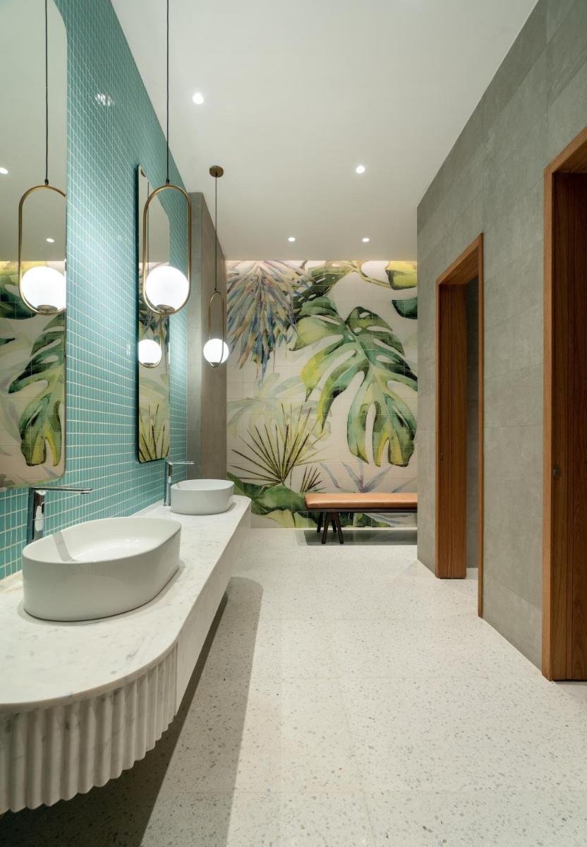 a bathroom with two sinks and a large mural at Greenpark Bengaluru in Bengaluru a bathroom with two sinks and a large mural at Greenpark Bengaluru in Bengaluru